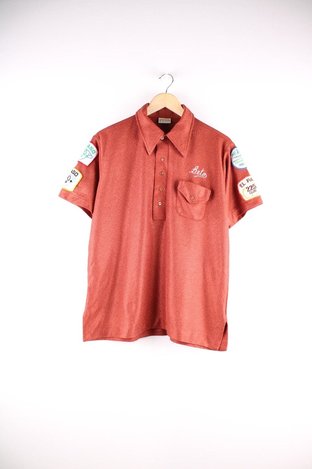 70s Vintage King Louie bowling shirt in metallic orange with a player name and club emblazoned on the front and back, and various competition patches on the sleeves.