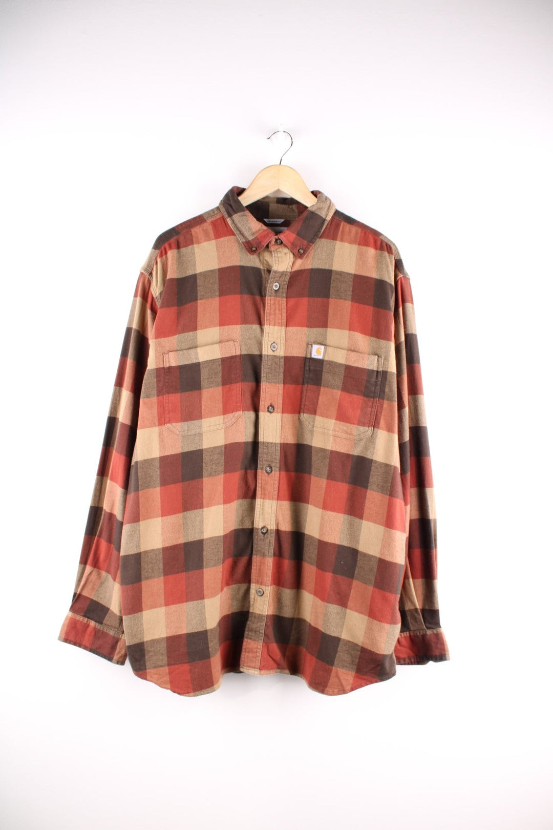 Carhartt button-down shirt in brown, red, and tan check, with two breast pockets and a small logo patch on the chest.