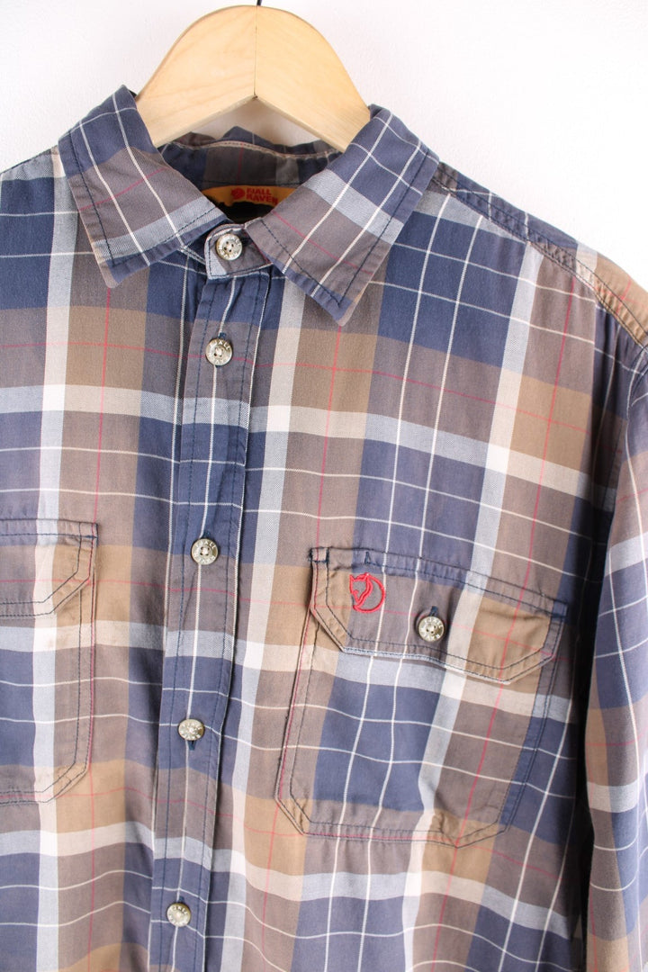 Fjallraven shirt in brown and grey check, with branded buttons, two buttoned pockets and fox logo embroidered in red.