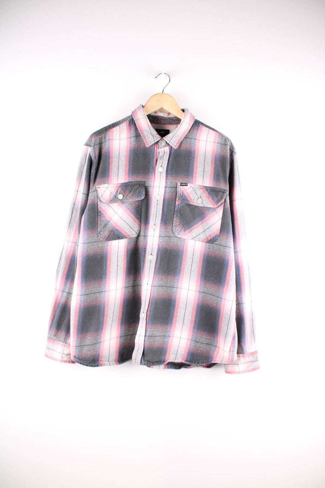 Vintage check shirt in pink, grey and white, with two buttoned pockets and a small O.B.E.Y. logo patch in black..