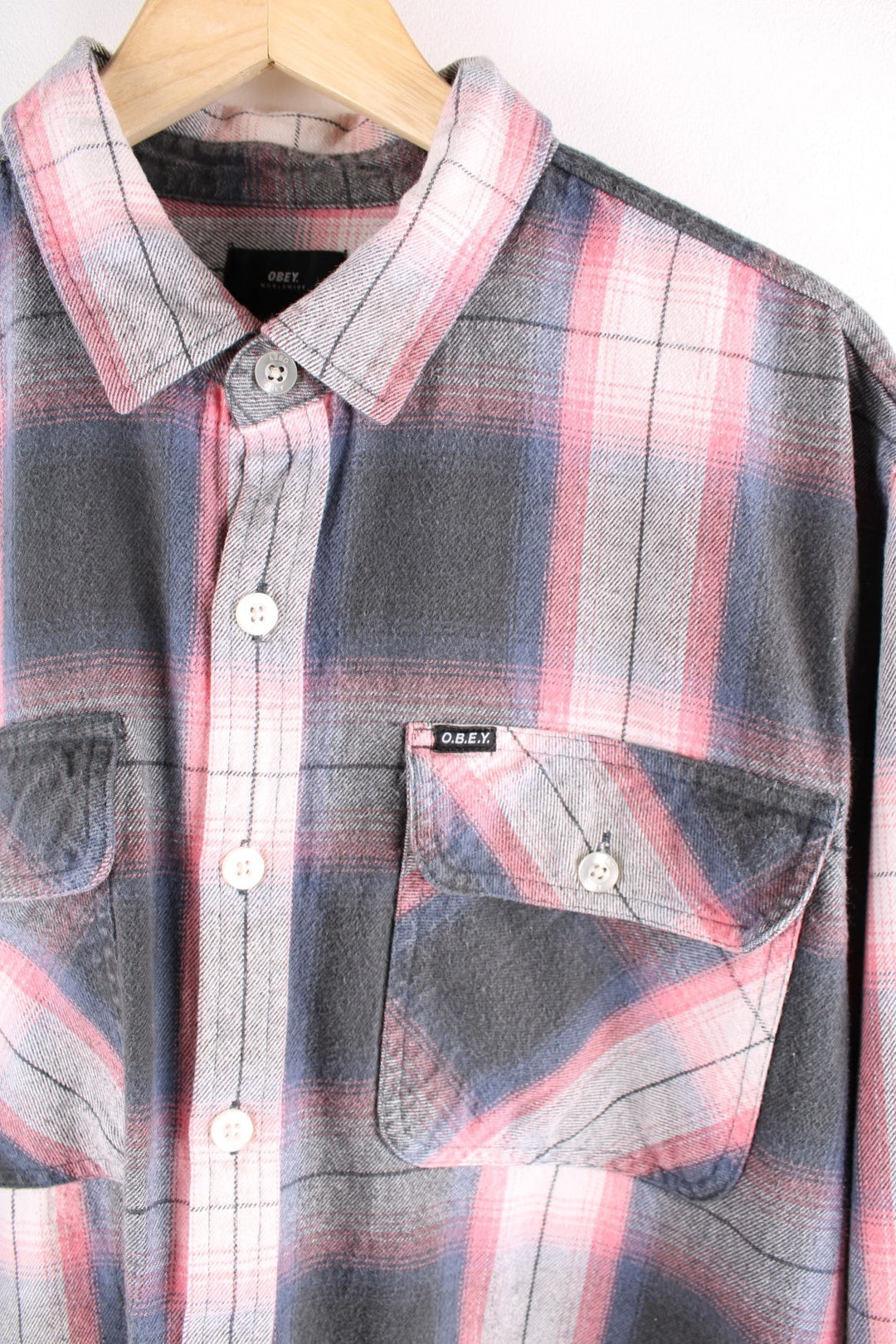 Vintage check shirt in pink, grey and white, with two buttoned pockets and a small O.B.E.Y. logo patch in black..