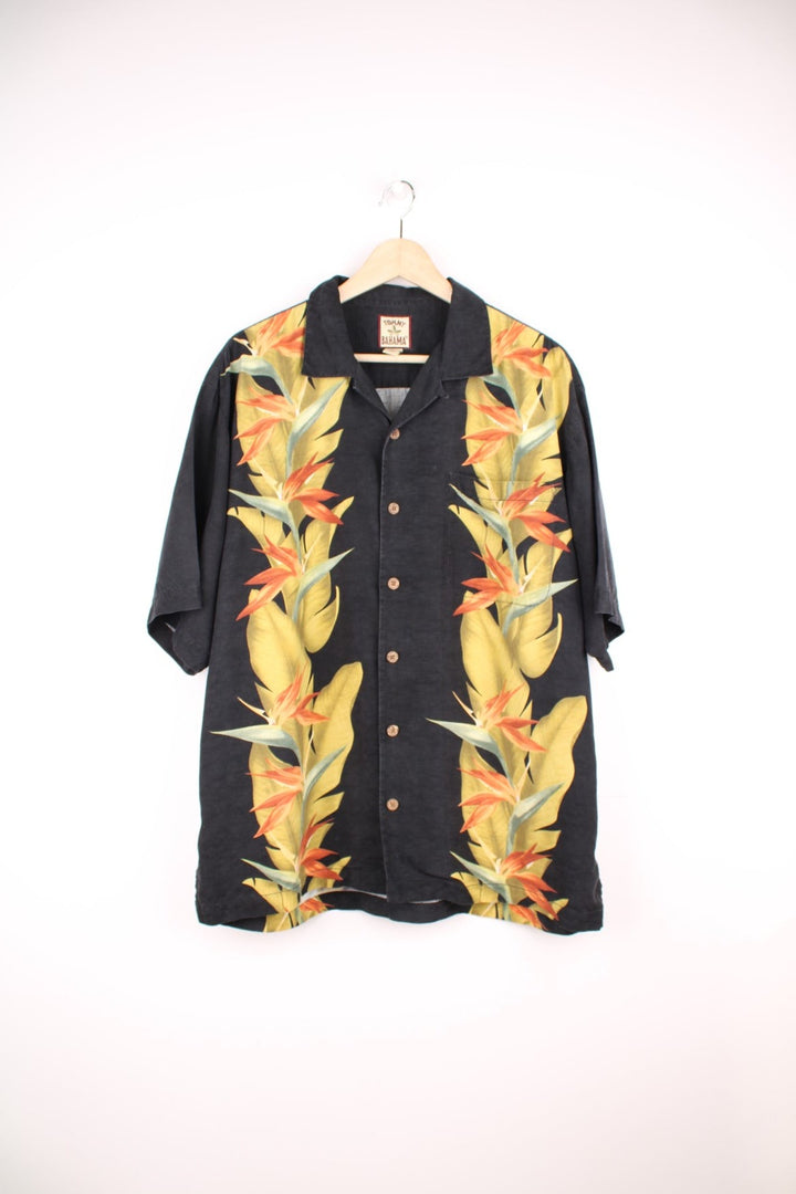 Vintage Tommy Bahama Hawaiian Shirt in a black colourway with floral pattern printed on the front and back, button up with a camp collar and has a chest pocket.