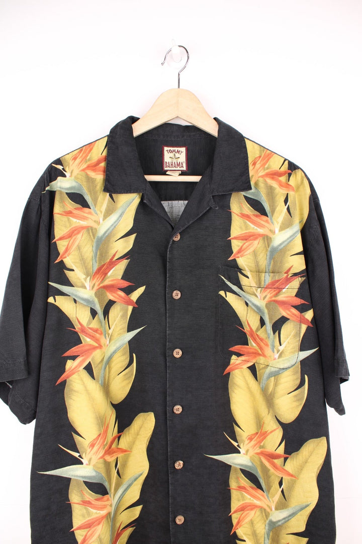 Vintage Tommy Bahama Hawaiian Shirt in a black colourway with floral pattern printed on the front and back, button up with a camp collar and has a chest pocket.