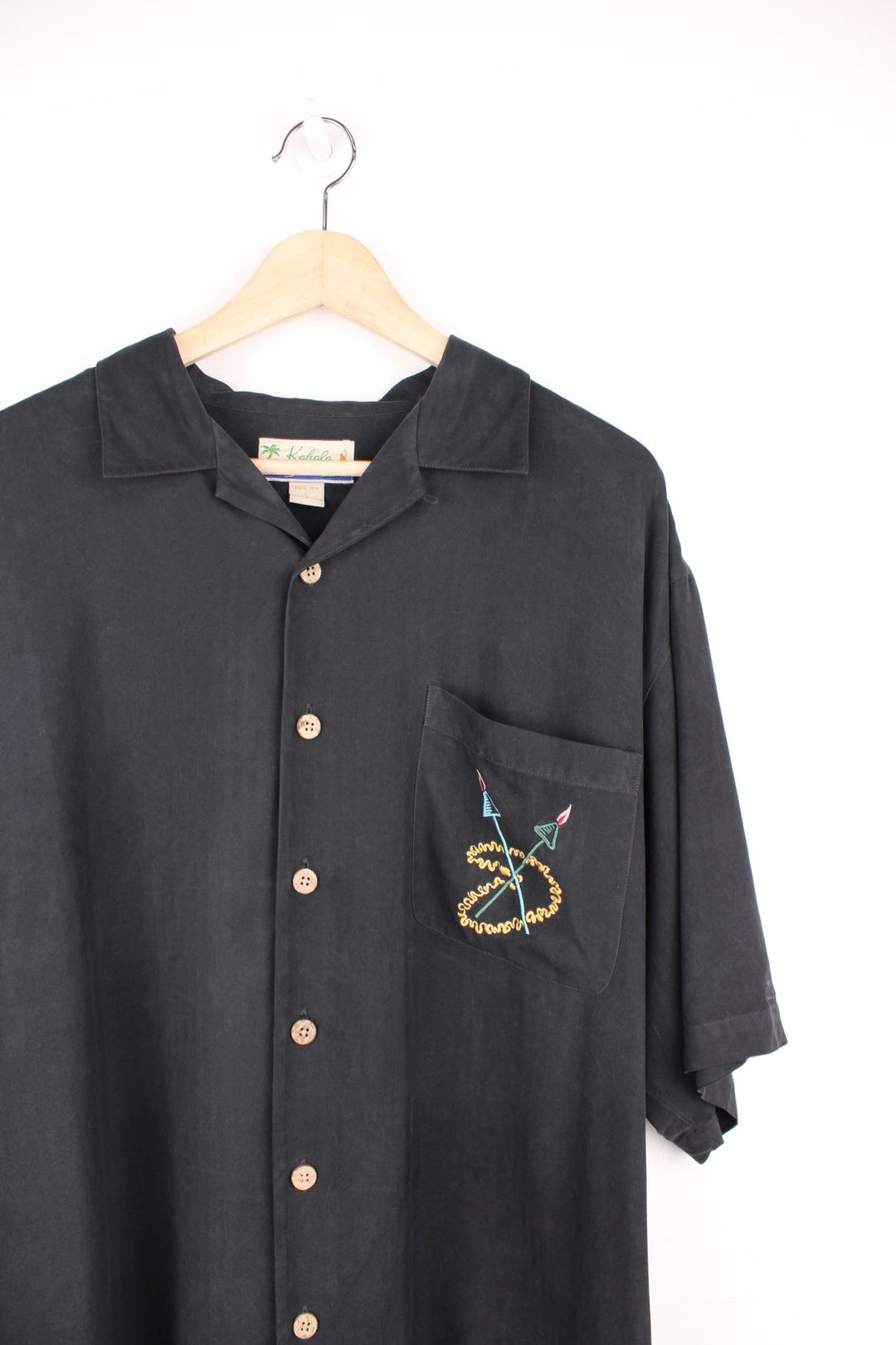 Vintage Kahala Tiki Lounge Hawaiian Shirt in a black colourway with with embroidered tiki lounge design on the front and back, button up with a camp collar, and has a chest pocket.