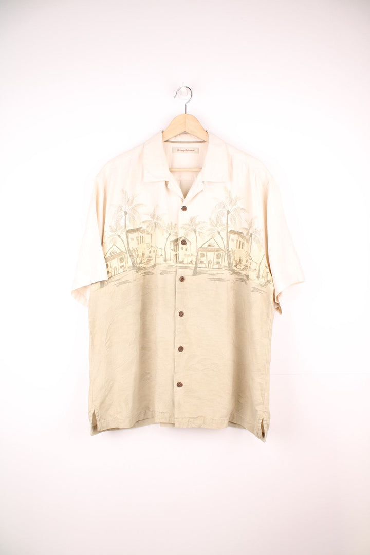 Vintage Tommy Bahama Hawaiian Shirt in white and tanned colourway with a floral design throughout and palm tree housing embroidered on the front, button up and has a camp collar.