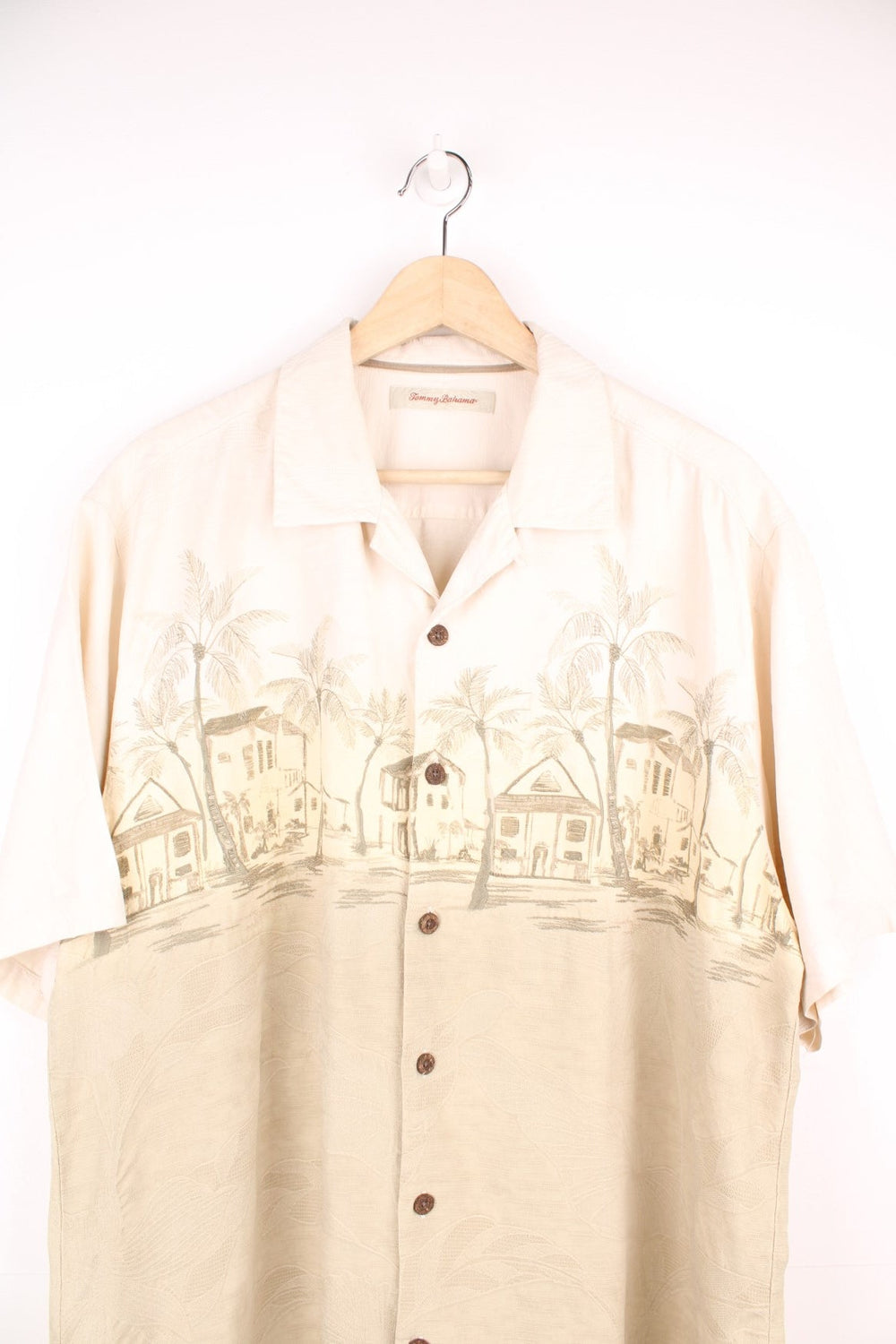 Vintage Tommy Bahama Hawaiian Shirt in white and tanned colourway with a floral design throughout and palm tree housing embroidered on the front, button up and has a camp collar.