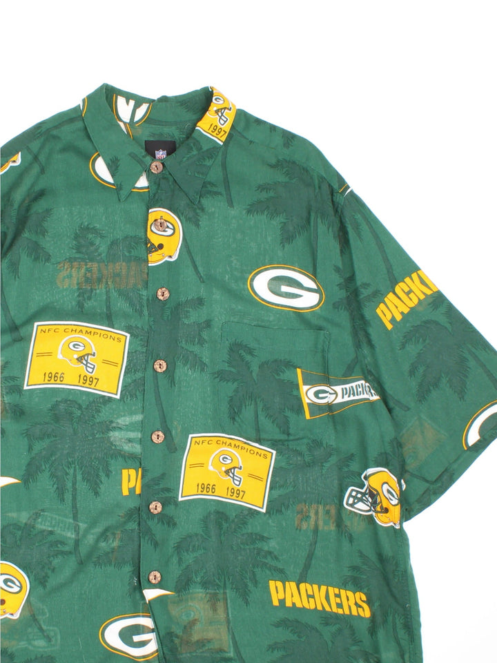 Green Bay Packers NFL Hawaiian Shirt in a green colourway, button up and has a chest pocket, and the team logo printed all over along with palm tree graphics.