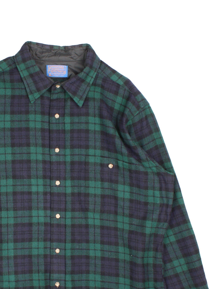 Pendleton Flannel Shirt in a green, blue and black plaid colourway, button up, has a chest pocket, and brown elbow pads.