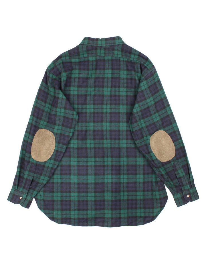 Pendleton Flannel Shirt in a green, blue and black plaid colourway, button up, has a chest pocket, and brown elbow pads.