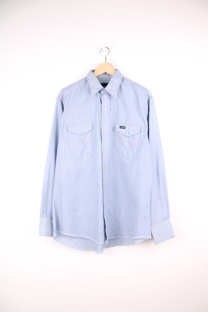 Vintage 70s blue Wrangler shirt with popper fastenings, chest pockets and embroidered logo.