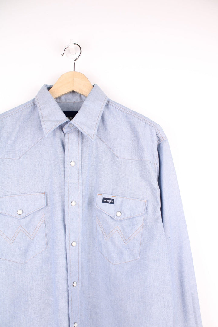 Vintage 70s blue Wrangler shirt with popper fastenings, chest pockets and embroidered logo.