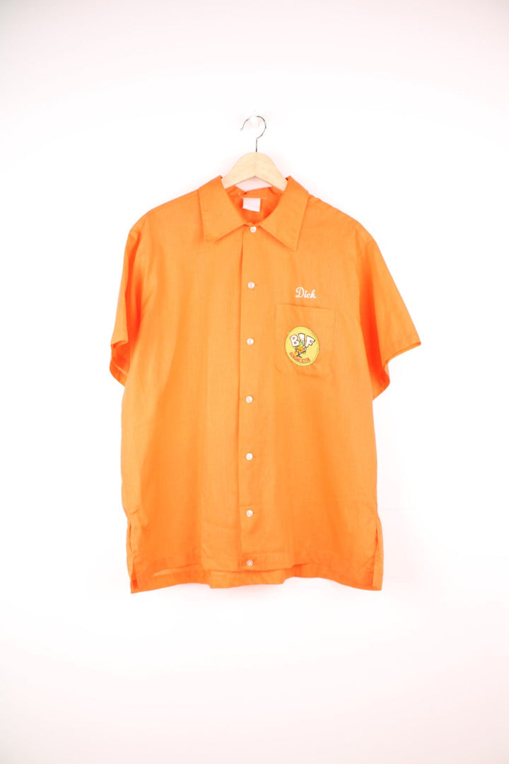 Vintage personalised bright orange short-sleeved bowling shirt with white buttons, a breast pocket, an added patch reading 'BIF Bowling Is Fun'. 