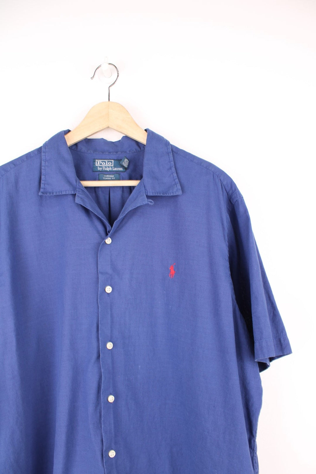 Dark blue short-sleeved Polo Ralph Lauren shirt with white buttons and the classic Polo logo embroidered in red.