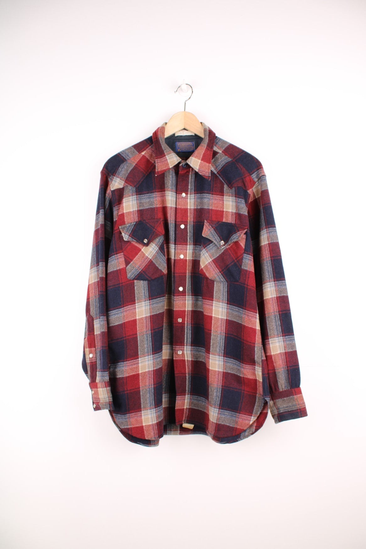 Vintage Pendleton western style Pearl Snap button through wool plaid shirt in red, blue and beige. Features chest pockets. 