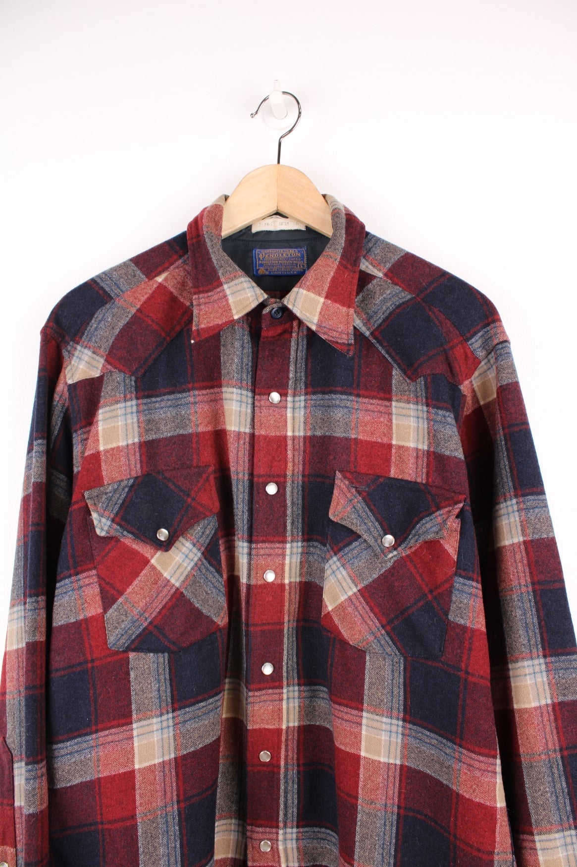 Vintage Pendleton western style Pearl Snap button through wool plaid shirt in red, blue and beige. Features chest pockets. 