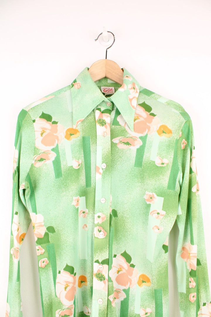 Vintage 70s Styled by Sybil green button through blouse with pink floral pattern and a dagger collar.