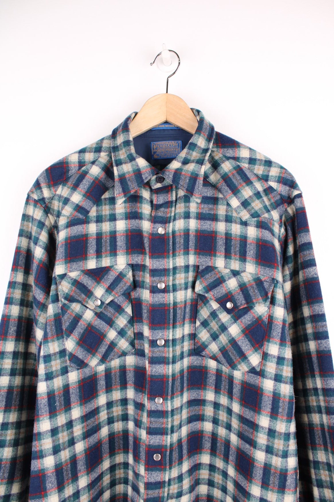 Vintage Pendleton wool plaid Pearl Snap shirt in blue, white and red. Features chest pockets and Western style yolk. 