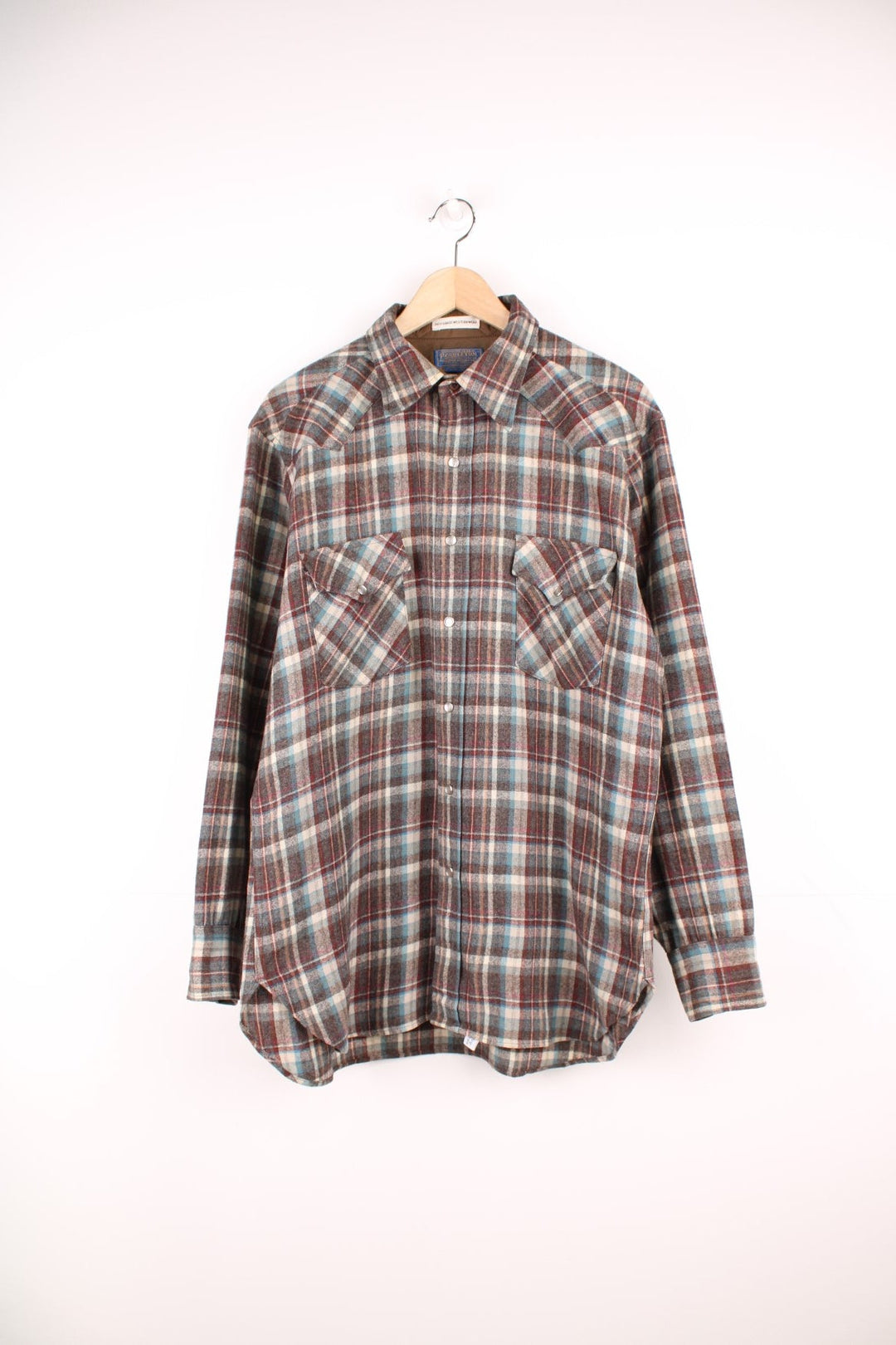 Vintage Pendleton wool plaid Pearl Snap shirt in grey, blue and red. Features chest pockets and Western style yolk. 