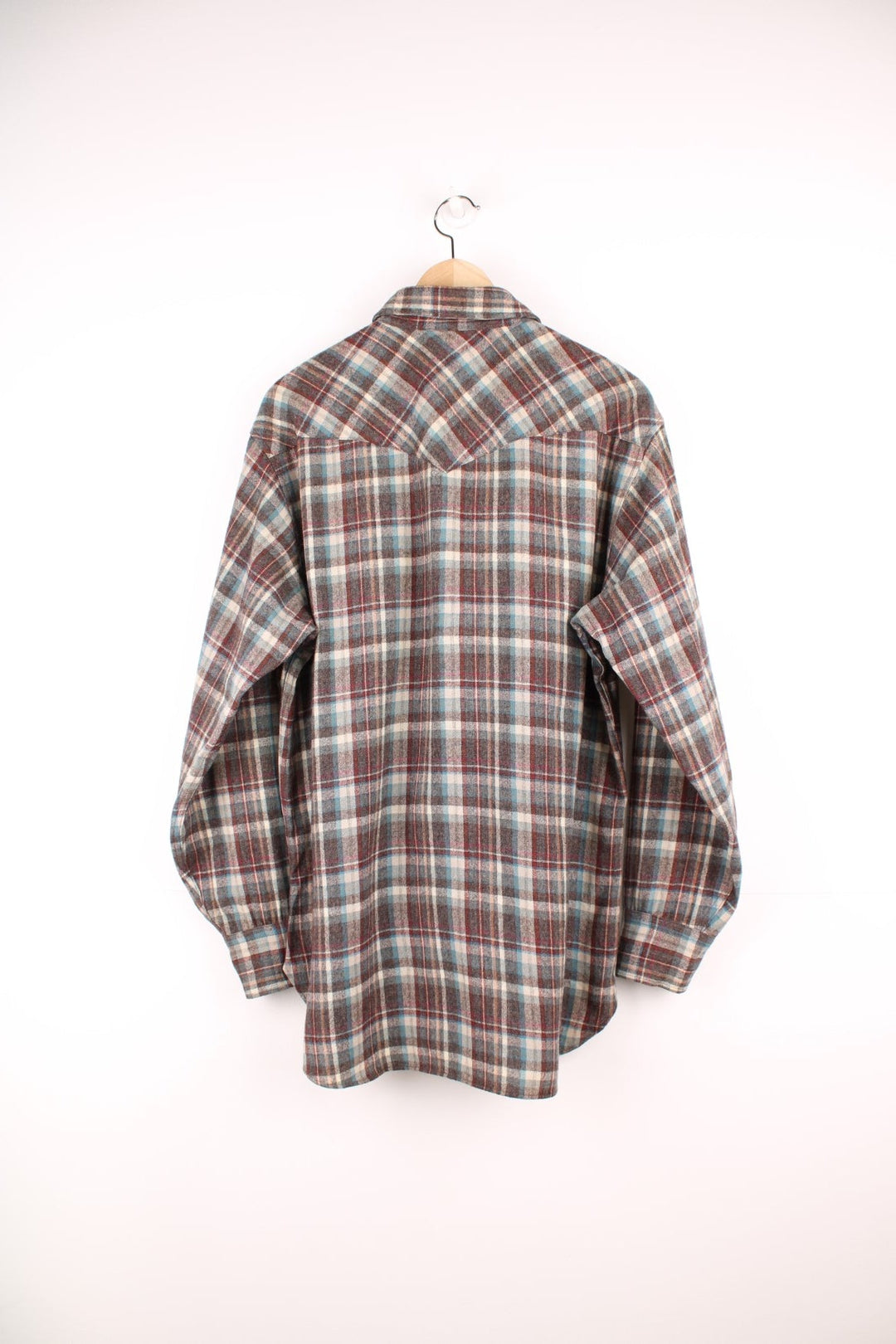 Vintage Pendleton wool plaid Pearl Snap shirt in grey, blue and red. Features chest pockets and Western style yolk. 