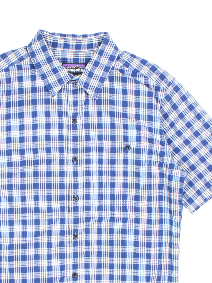 Patagonia short-sleeved textured shirt in blue and white checkered colourway with one pocket.