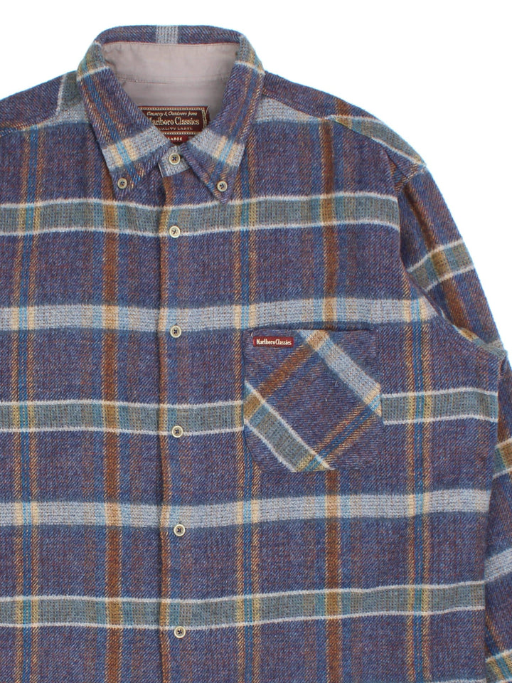 Marlboro Classics Shirt in a blue/brown plaid colourway, button up with the logo patch embroidered on the front left.