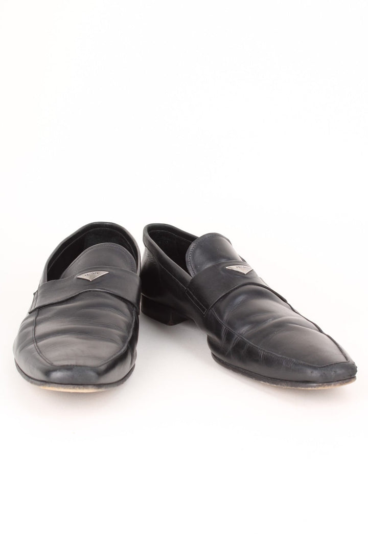 Vintage Prada Loafers in a black colourway with the badge logo embroidered on the front and side heels.