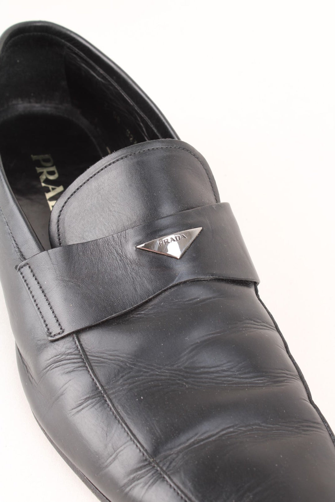 Vintage Prada Loafers in a black colourway with the badge logo embroidered on the front and side heels.