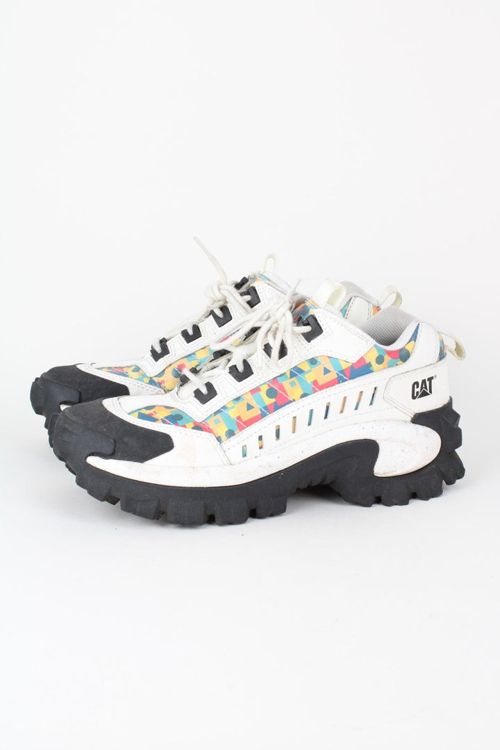 Vintage CAT Caterpillar Intruder Shoes in a white colourway with multicoloured patterned stripe going down the sides, and has laces.