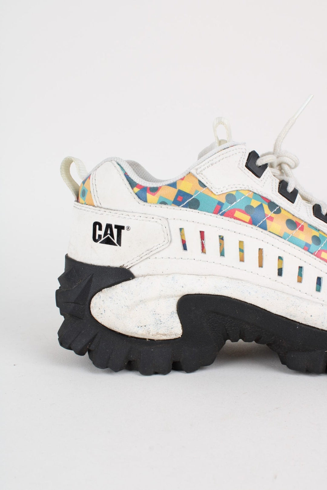 Vintage CAT Caterpillar Intruder Shoes in a white colourway with multicoloured patterned stripe going down the sides, and has laces.