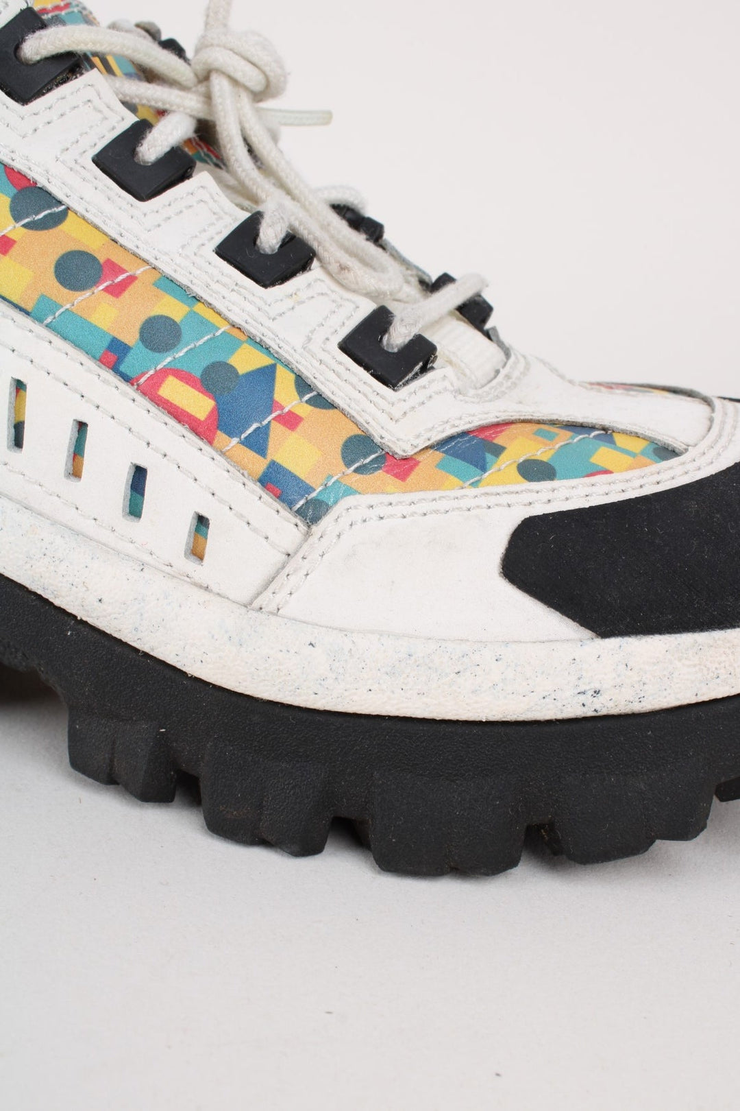 Vintage CAT Caterpillar Intruder Shoes in a white colourway with multicoloured patterned stripe going down the sides, and has laces.