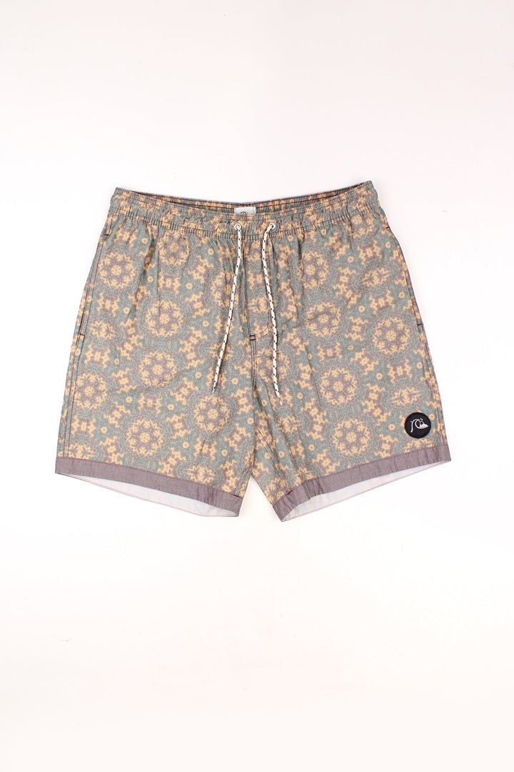 Vintage Quiksilver Shorts in a green, yellow and brown patterned colourway, adjustable waist, and has the logo embroidered on the front and back. 