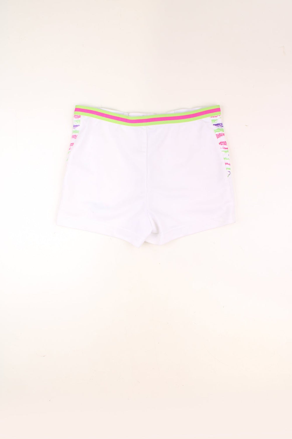 Vintage Fila Tennis Shorts in a white colourway with a multicoloured pattern print by the side pockets, and has the logo embroidered on the front. 