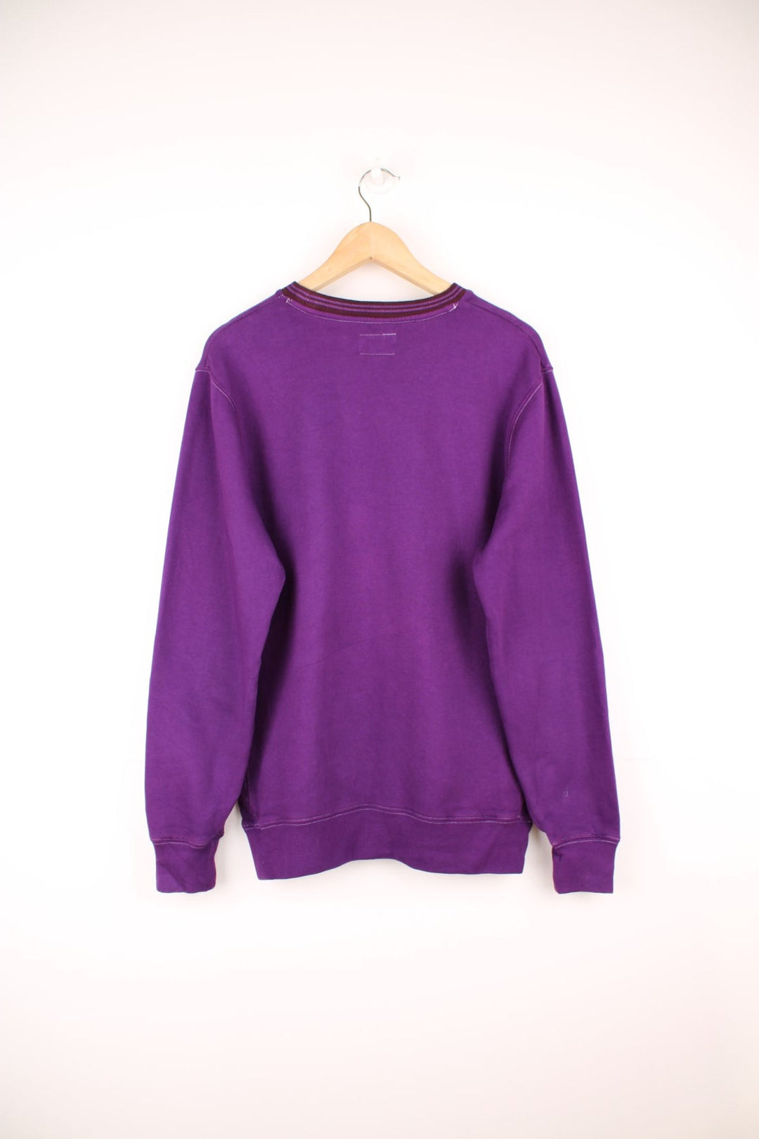 Stussy crew neck sweatshirt in purple with a contrast collar and embroidered logo across the chest in brown.