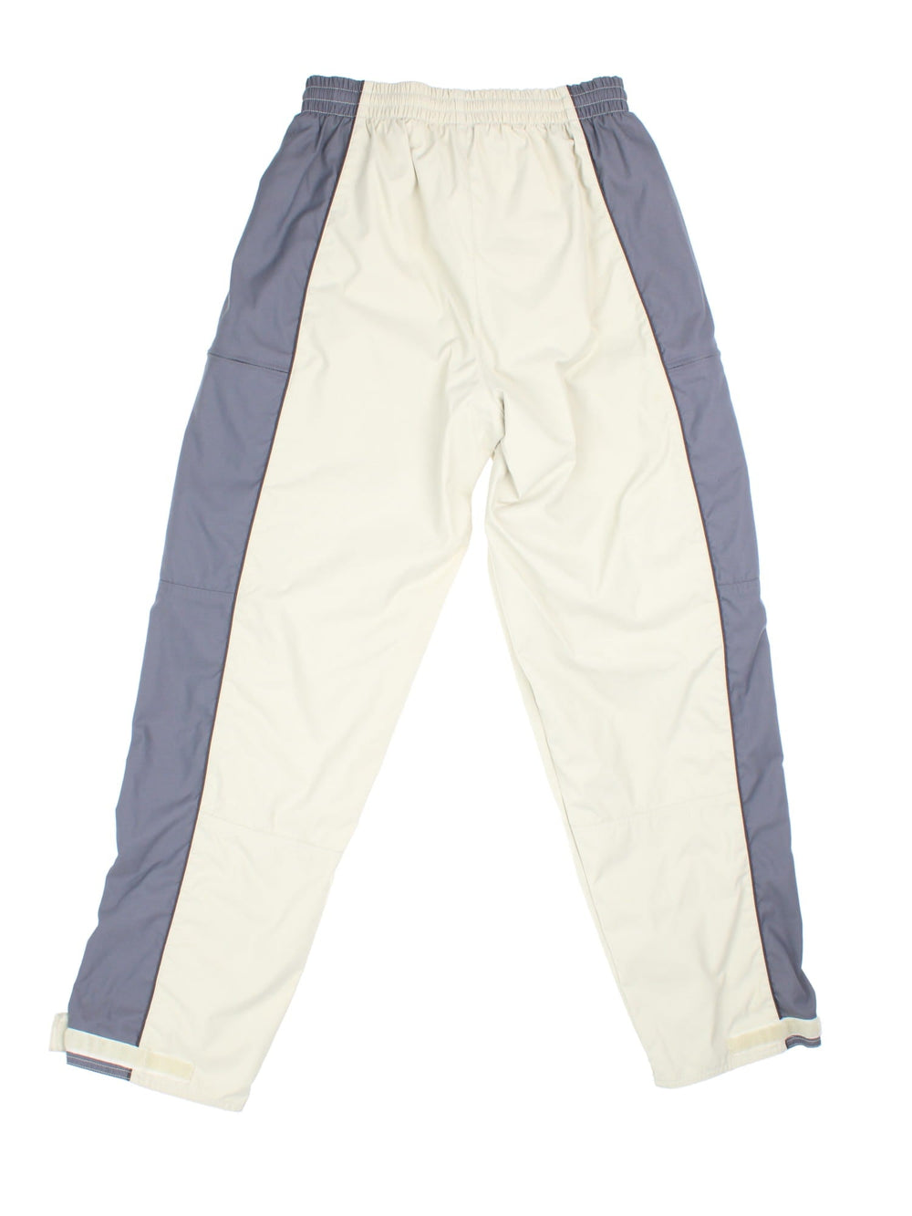 Nike 90s tracksuit bottoms in tan and grey with two zipped pockets, an elasticated waist, and an embroidered swoosh logo.