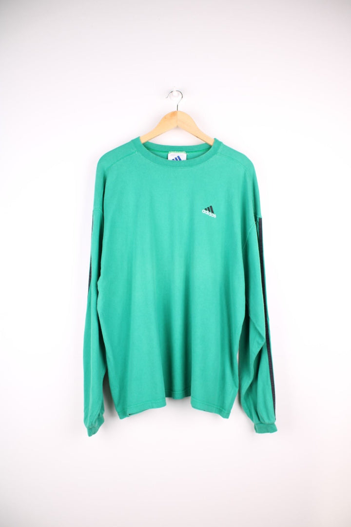 Vintage 1990s longsleeved Adidas T-Shirt in a green colourway with the Adidas logo embroidered on the front and three stripes stitched down the sleeves.