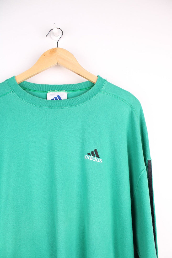 Vintage 1990s longsleeved Adidas T-Shirt in a green colourway with the Adidas logo embroidered on the front and three stripes stitched down the sleeves.