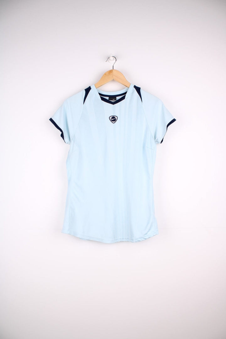 Y2K era Nike T-Shirt in a lightblue colourway. Football Tee style with navy piped cuffs, capped sleeves, and the Nike logo patch on the front. 