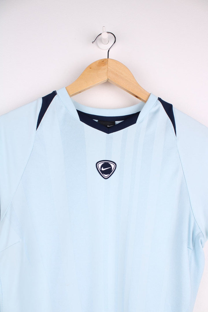 Y2K era Nike T-Shirt in a lightblue colourway. Football Tee style with navy piped cuffs, capped sleeves, and the Nike logo patch on the front. 