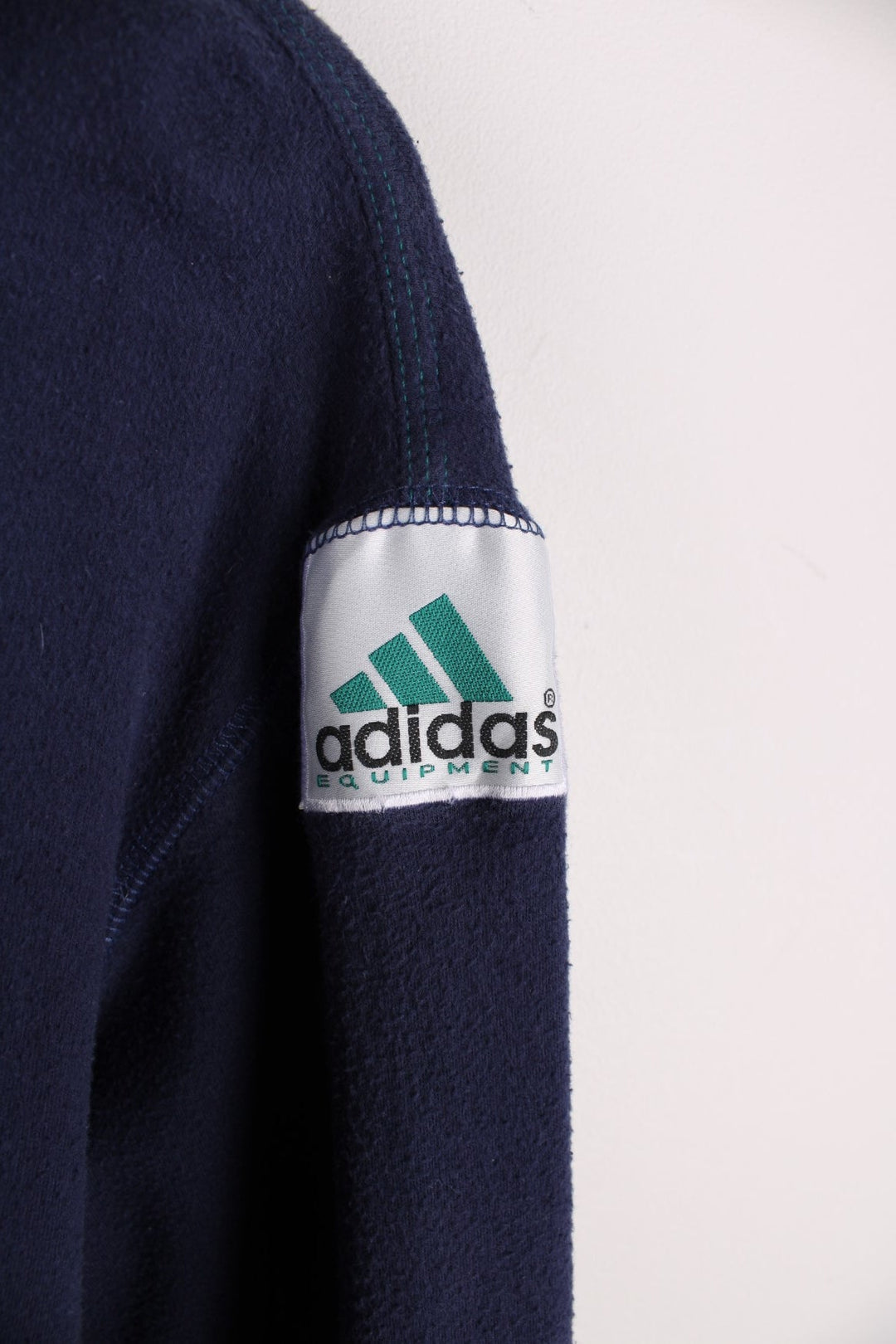 1990s Adidas Equipment longsleeve T-Shirt in a navy blue colourway with the logo embroidered on the collar and a patch sewn into the arm.