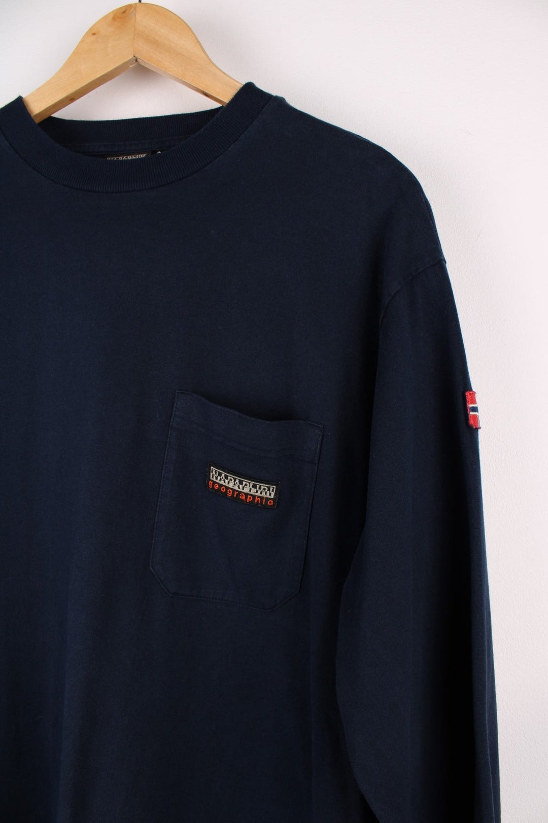 Napapijri long sleeve T-Shirt in a navyblue colourway with a front patch pocket, stiched logo and a Norwegian flag stitched on the arm.