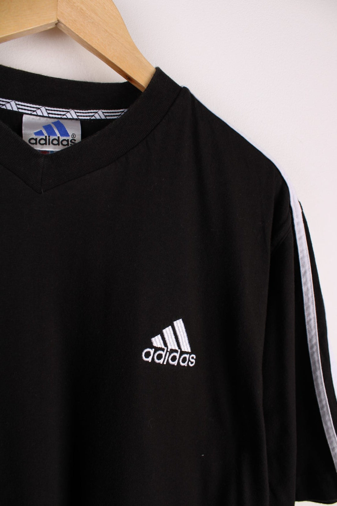 1990s Adidas T-Shirt in a black colourway with the logo embroidered on the front and three stripes stitched down the sleeves. 