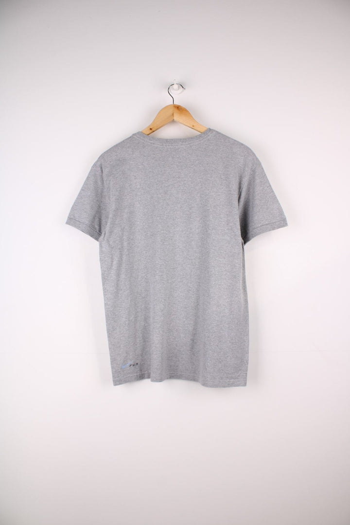 Vintage Nike Run T-Shirt in a grey colourway with a small shoe graphic printed on the front. The shirt has a V neck and capped sleeves. 