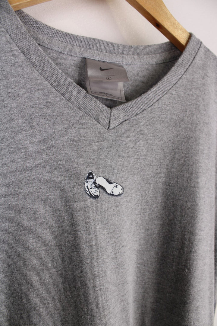 Vintage Nike Run T-Shirt in a grey colourway with a small shoe graphic printed on the front. The shirt has a V neck and capped sleeves. 