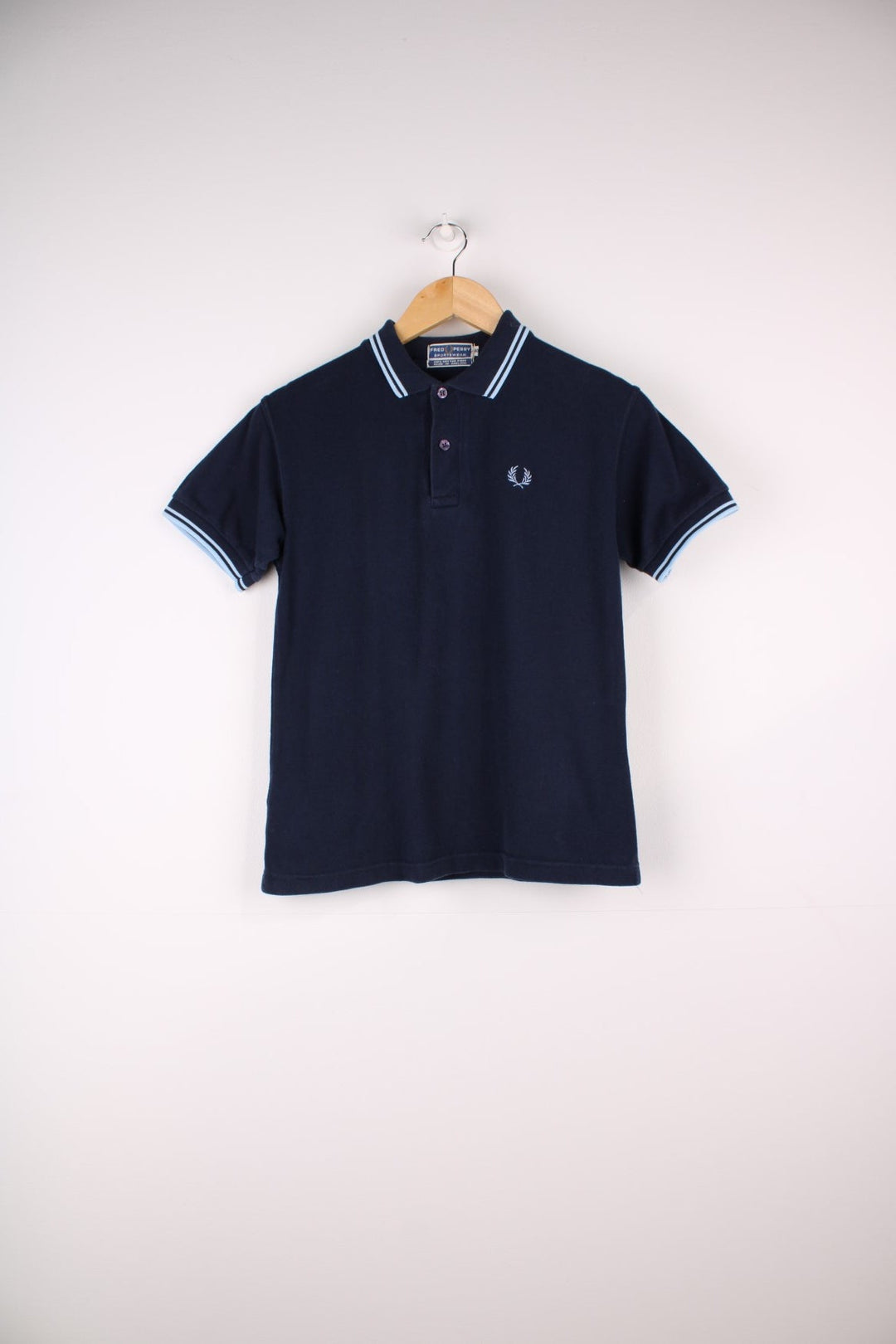 1980s Fred Perry Polo shirt in a navy blue colourway with the logo embroidered on the front. Two stripes on the collar and sleeves.