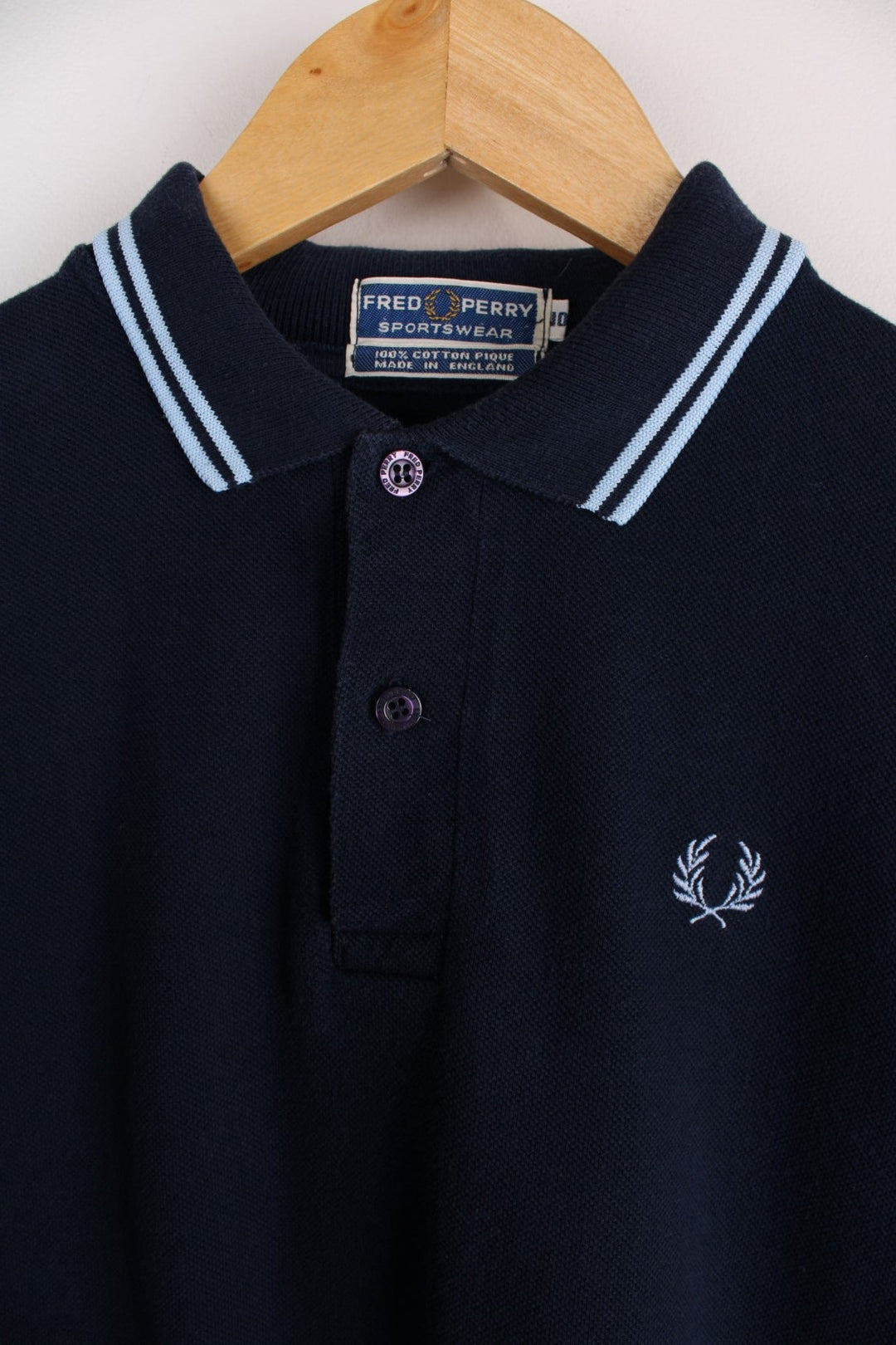 1980s Fred Perry Polo shirt in a navy blue colourway with the logo embroidered on the front. Two stripes on the collar and sleeves.