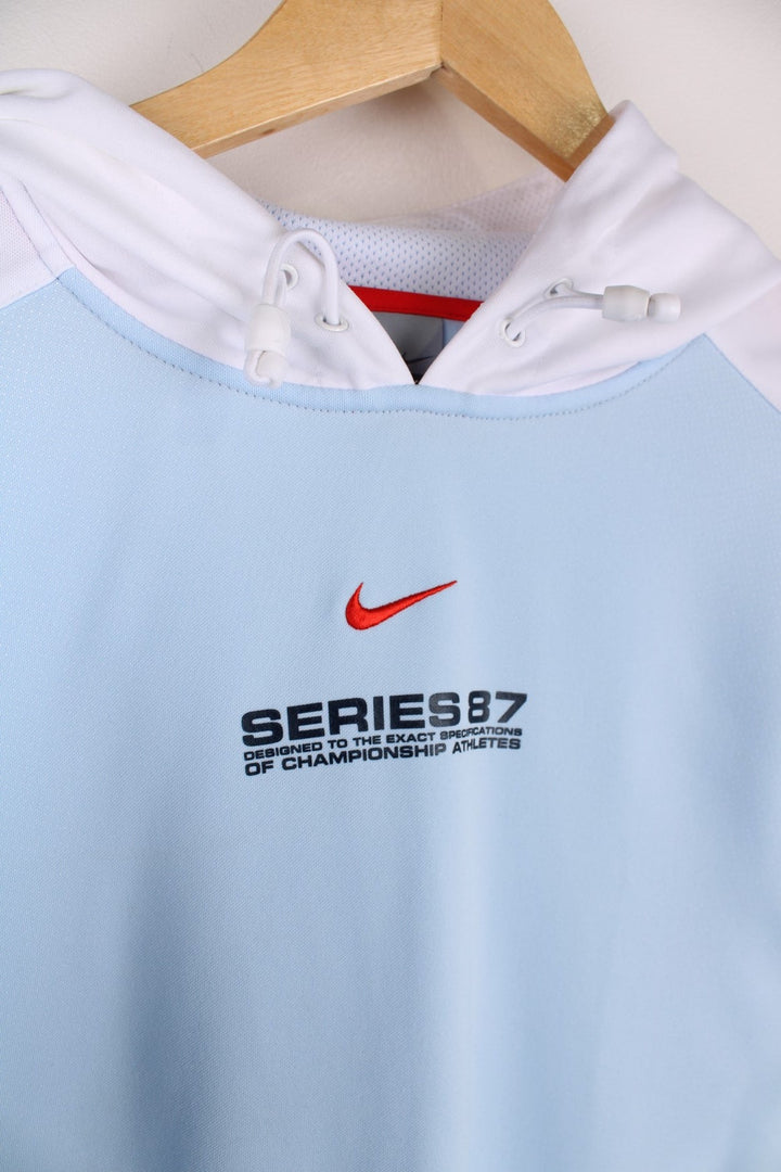 Nike sleeveless hoodie in a blue colourway with white mesh sides,and navy piping cord edges.The logo and graphic are printed on the front centre.