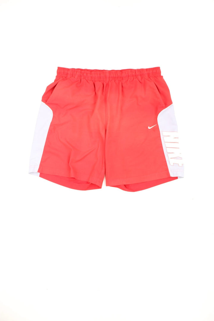 Red Nike drawstring swim shorts with embroidered logo and printed logo down the leg.