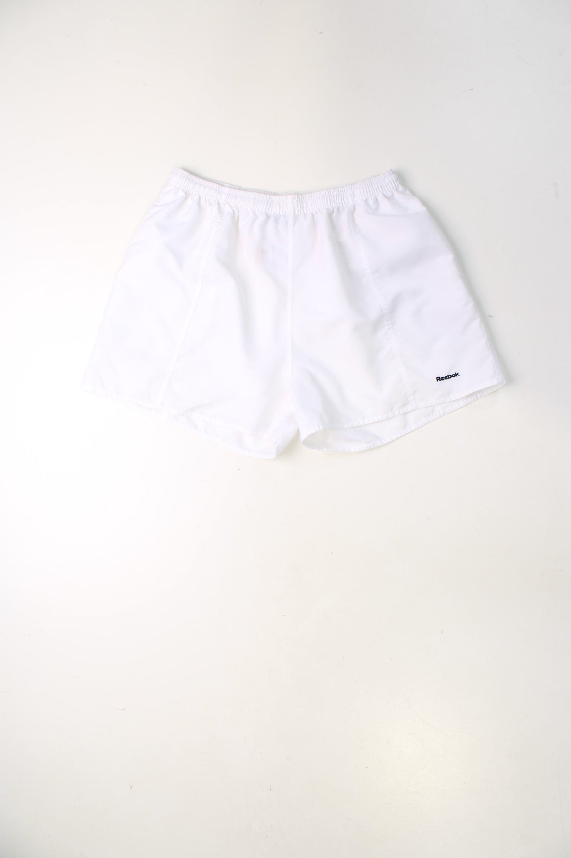 White Reebok shorts with elasticated drawstring waist and embroidered logo.