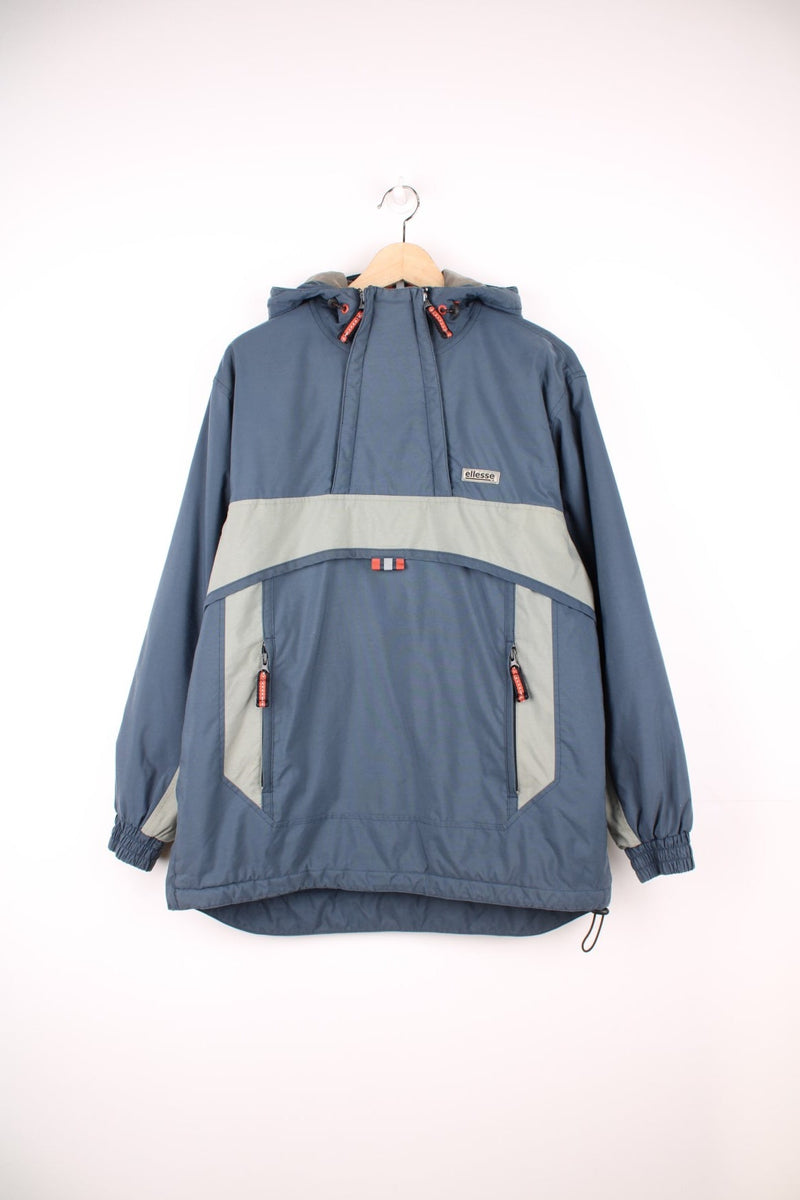 Ellesse Pullover Jacket in a blue and grey colourway, half zips on the front do not zip down fully only for more space / air, has side pockets, hooded and the logo is embroidered on the front. 