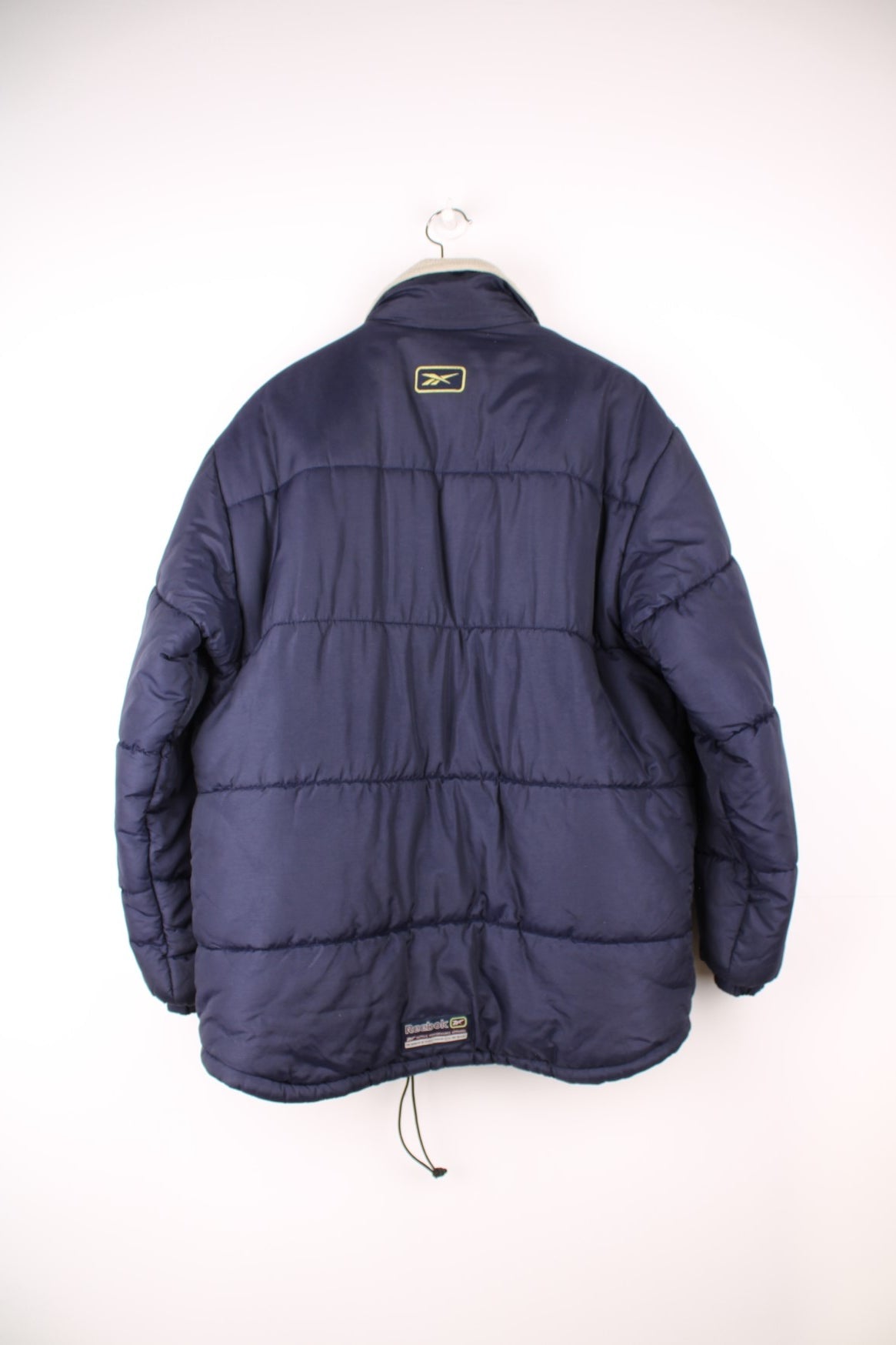 Reebok Puffer Coat in a blue colourway, zip up with side pockets, insulated lining, and has the logo embroidered on the front and back. 